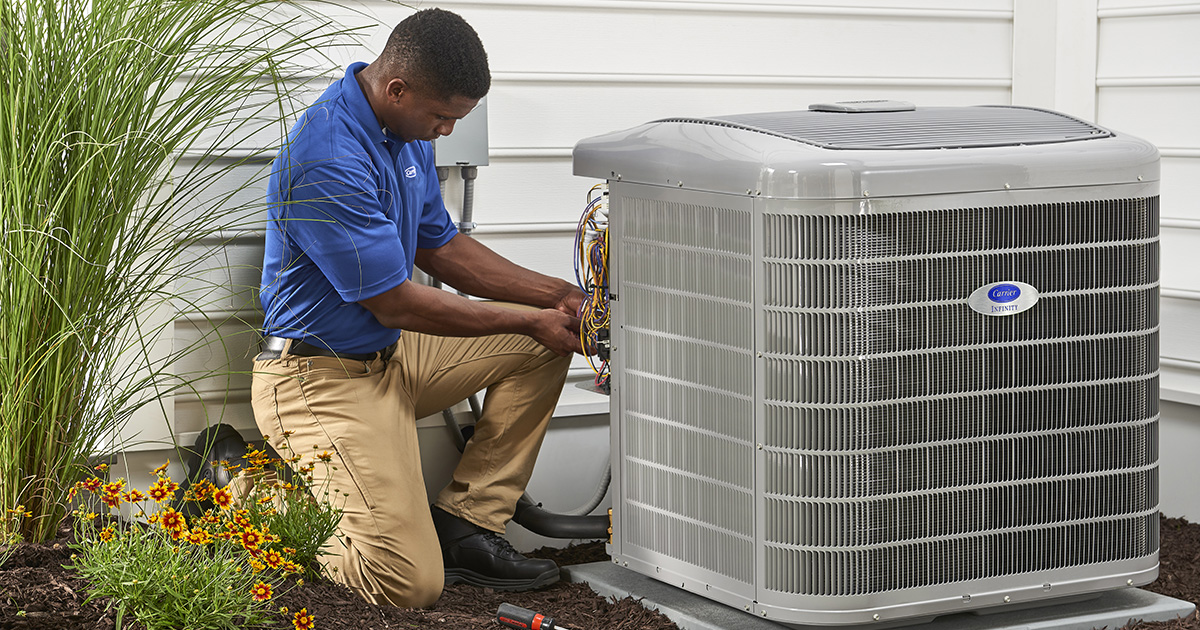 HVAC technician servicing an air conditioner condenser beside a home